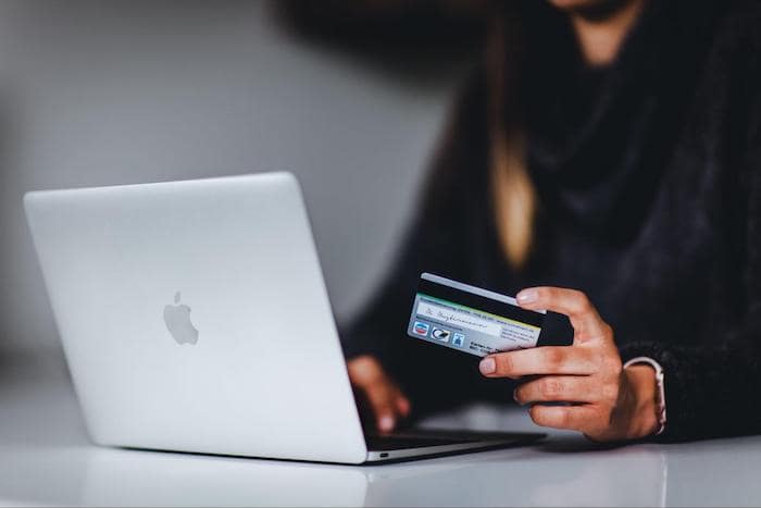 A person using a laptop and credit card to shop online
