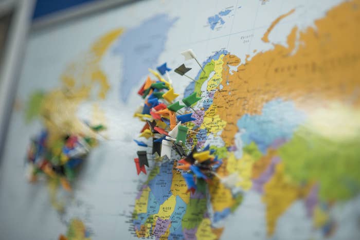 A wall map with flagged pins showing the customers we have across the world