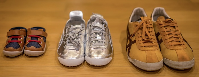 Two adult and one child's pair of trainers lined up
